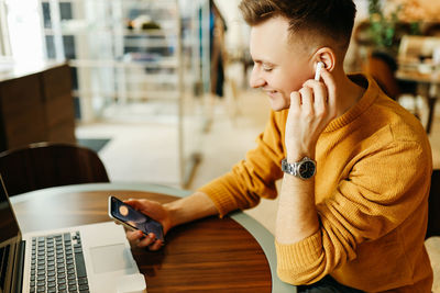 Happy smiling cool young business man freelance student working with wireless technology in a cafe