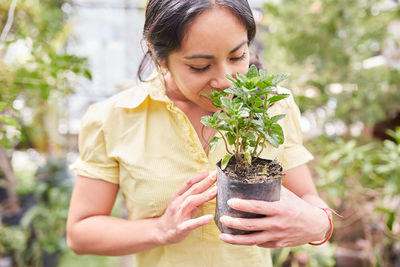 Midsection of woman holding plant