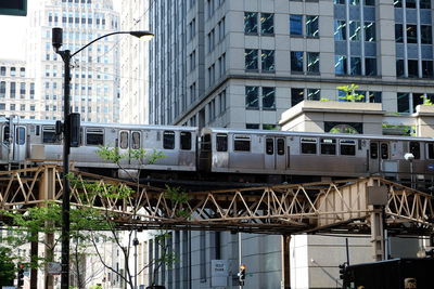 Train on bridge against buildings in city