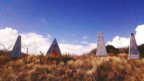 Built structure on field against blue sky