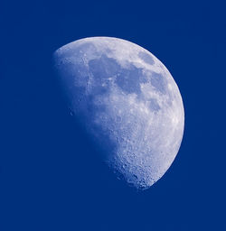 Low angle view of moon against clear blue sky