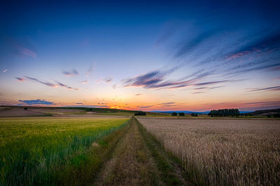 Scenic view of agricultural field against dramatic sky