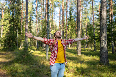 Rear view of woman standing in forest