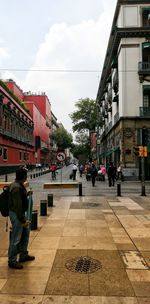 People walking on street against buildings in city