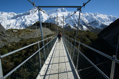 Rear view of person standing on footbridge