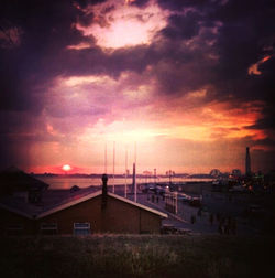 Scenic view of sea and buildings against dramatic sky