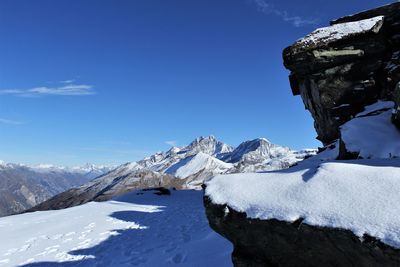 Scenic view of snowcapped mountains against blue sky at gornergrat railway station, switzerland