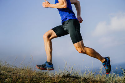 Low section of woman exercising against sky