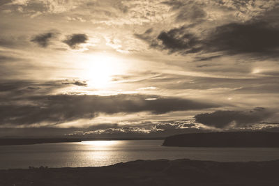 Scenic view of sea against cloudy sky at sunset