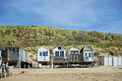 Houses by sea against sky