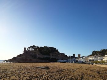 Built structure on beach against clear blue sky