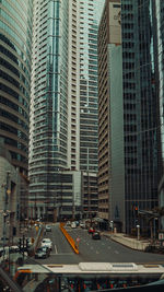 Vehicles on road amidst buildings in city