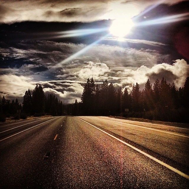 transportation, the way forward, road, sky, diminishing perspective, road marking, vanishing point, cloud - sky, country road, empty road, street, tree, sun, empty, tranquility, weather, nature, sunbeam, tranquil scene, landscape