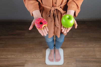 Midsection of woman holding apple