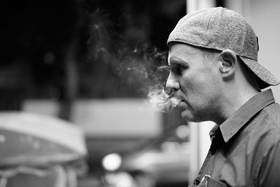 Portrait of man smoking cigarette outdoors