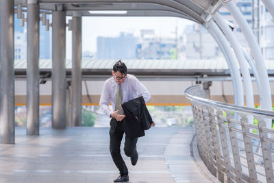 Mid adult businessman running on elevated walkway