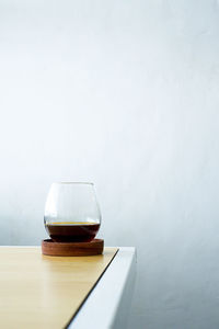Close-up of drink on table against wall