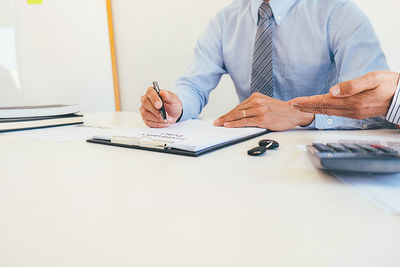 Midsection of man working on table