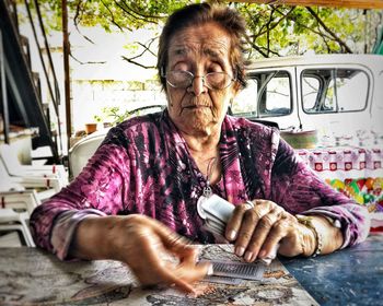 Senior woman playing cards on table