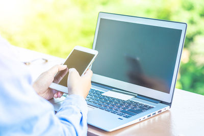 Cropped image of woman doing online shopping at desk