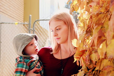 Close-up of mother and daughter in autumn leaves