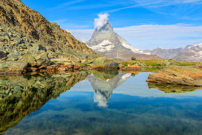 Scenic view of lake and mountains against sky