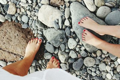 Woman and girl's feet on pebbly beach