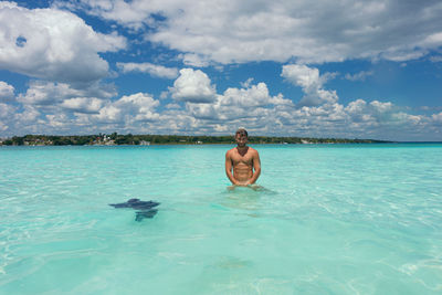 Young woman swimming in sea against sky