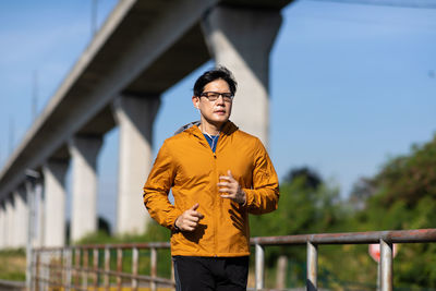 Young man running on bridge