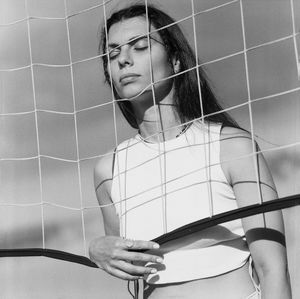 Low angle view of young woman looking through window