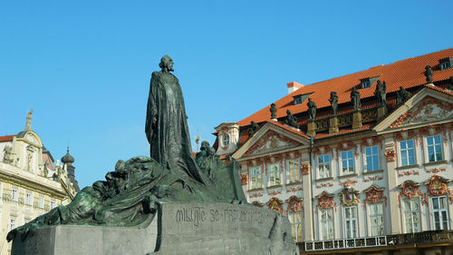 Low angle view of statue against buildings in city