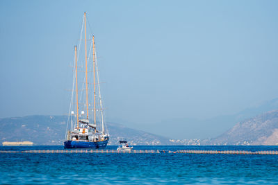 Sailboat sailing in sea against clear sky