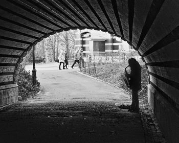 Full length of silhouette street musician playing saxophone at tunnel