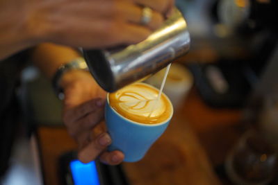 Man pouring coffee in cup