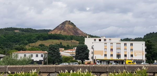 Houses by buildings against sky