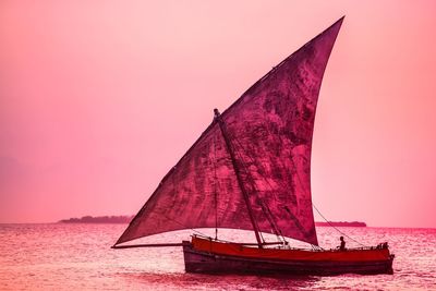 Sailboat on sea against sky during sunset