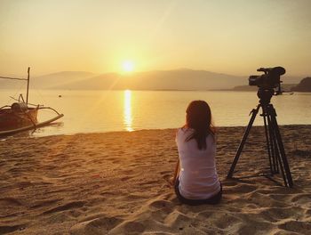 People sitting on beach at sunset