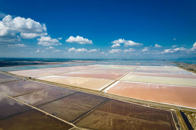 Scenic view of agricultural landscape against blue sky