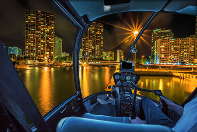 Illuminated modern building by river at night