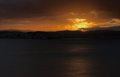 Scenic view of silhouette mountains against romantic sky at sunset