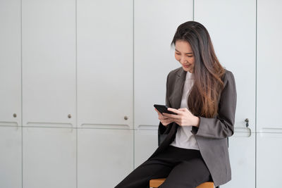 Smiling businesswoman using mobile phone