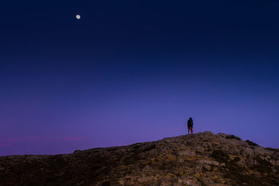 Low angle view of people standing on rock formation