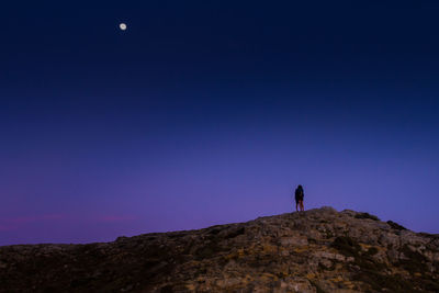 Couple on rock against sky