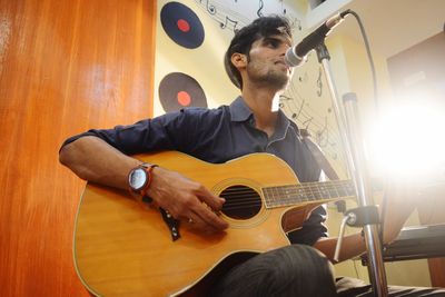 Man playing guitar at home