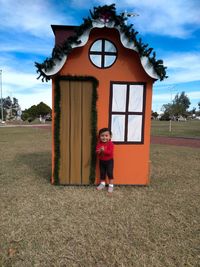 Portrait of girl standing against shed