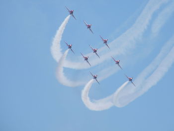 Low angle view of airshow against clear blue sky