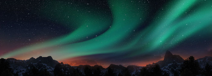 Scenic view of snowcapped mountains against sky at night