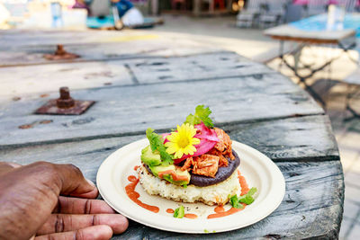 Cropped hand of woman holding food on table