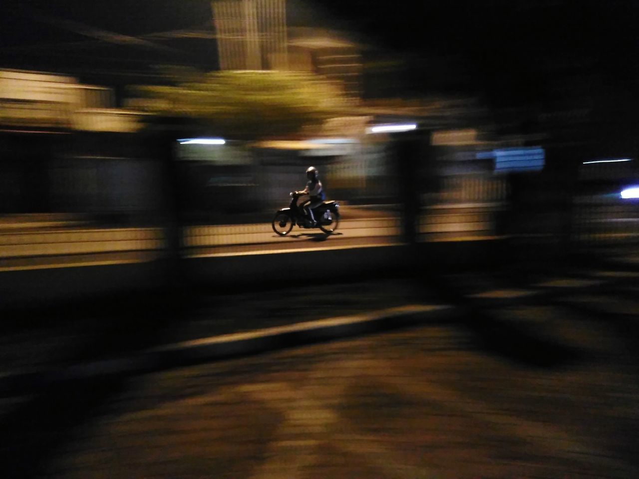 BLURRED MOTION OF PERSON RIDING MOTORCYCLE ON ROAD