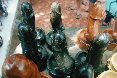 Close-up of phallus shape wooden art for sale on table